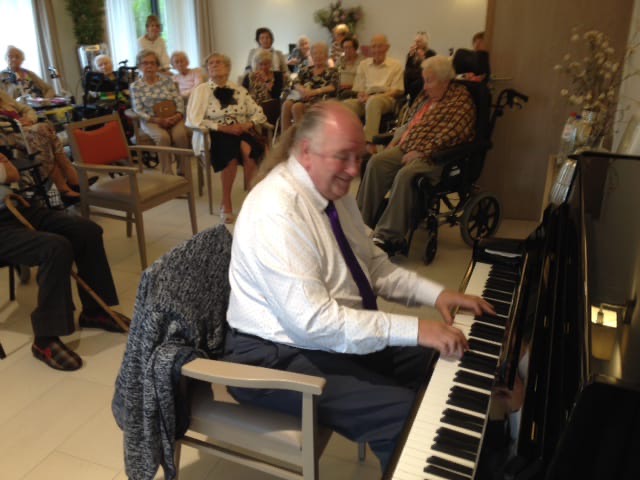 Jos speelt piano voor bewoners van een woonzorgcentrum